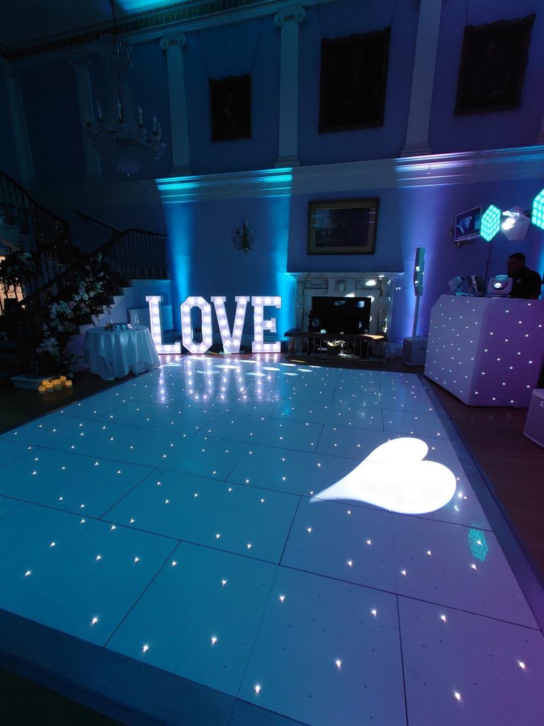 Hire love letters in hertfordshire - nextLOVE Letters – From £175 Our 4ft ‘LOVE’ letters are the essence of romance turned into a radiant spectacle. Each letter stands tall, casting a soft, inviting glow that harmonises with the joyful celebration of your union. These aren’t just letters; they are the beacons of your love story, meticulously designed with bright, energy-efficient LED bulbs that offer an enchanting luminescence to your venue. Whether nestled by the dance floor, welcoming guests at the entrance, or serving as an exquisite photo backdrop, our ‘LOVE’ letters are more than decor—they are a memorable experience. Their timeless design complements any wedding theme, from the ultra-modern to the whimsically vintage, transforming your space into a storybook setting. Mr & Mrs Letters – From £225 LOVE Letters – From £175 Our 4ft ‘LOVE’ letters are the essence of romance turned into a radiant spectacle. Each letter stands tall, casting a soft, inviting glow that harmonises with the joyful celebration of your union. These aren’t just letters; they are the beacons of your love story, meticulously designed with bright, energy-efficient LED bulbs that offer an enchanting luminescence to your venue. Whether nestled by the dance floor, welcoming guests at the entrance, or serving as an exquisite photo backdrop, our ‘LOVE’ letters are more than decor—they are a memorable experience. Their timeless design complements any wedding theme, from the ultra-modern to the whimsically vintage, transforming your space into a storybook setting. Mr & Mrs Letters – From £225 Celebrate the beginning of your forever with our ‘Mr & Mrs’ letters, a testament to your newly shared surname. These 4ft symbols of commitment and togetherness are not only an elegant decorative element but also a tribute to the journey you embark upon as life partners. Each character glows with the promise of future happiness, standing as a proud announcement of your marital bond. The letters’ soft lighting adds an air of sophistication to your reception, inviting guests to revel in the essence of your wedding day. Designed with versatility in mind, they adapt seamlessly to any setting, providing a focal point that is both visually stunning and deeply personal. These letters don’t just spell out a title; they encapsulate the essence of the wedding celebration—unity, love, and a touch of grandeur.