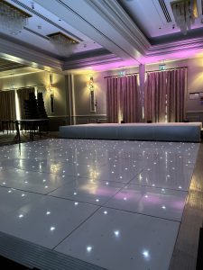 At Nextwave Events & Hire, we specialise in providing exceptional dance floor solutions to elevate your event’s atmosphere, creating an unforgettable experience for all your guests. Whether you’re planning a wedding, corporate event, or any festive occasion, our exquisite range of LED and plain dance floors are perfect for bringing a touch of elegance and vibrancy to your celebration. LED Dance Floor Hire Our LED dance floors are the pinnacle of modern event entertainment. They are designed to captivate and energise your guests, ensuring a lively and memorable party atmosphere. These stunning dance floors come with integrated LED lights that can be programmed to match the theme and color scheme of your event. With their sparkling, starlit effect, they add a magical touch to your venue, making them a popular choice for weddings and gala events. Starlit Dancefloor Hire The starlit dance floor is a crowd favorite, perfect for adding a romantic and enchanting ambiance to your event. These floors are beautifully lit with hundreds of tiny LED lights, resembling a starry night sky. They create a mesmerising effect that not only enhances the beauty of your venue but also encourages your guests to dance the night away under a canopy of twinkling stars. Serving Hertfordshire, Bedfordshire, and London We proudly serve a wide area, including Hertfordshire, Bedfordshire, and London. Our service locations include: St Albans: Known for its historical significance and beautiful architecture, St. Albans provides the perfect backdrop for our elegant dance floors. Hemel Hempstead: In the bustling town of Hemel Hempstead, our dance floors bring an extra layer of excitement and sophistication to any event. Luton: Luton’s vibrant community and diverse event venues are ideal settings for our stunning dance floors. Watford: In Watford, our dance floors complement both intimate gatherings and large-scale events, adding a touch of class and fun. Harpenden, Welwyn Garden City, and Hatfield: These picturesque towns are ideal for weddings and corporate events where our dance floors can shine. Milton Keynes: In the dynamic city of Milton Keynes, our dance floors are a popular choice for a variety of events, from corporate functions to celebratory parties. Variety of Sizes and Styles We understand that every venue and event theme is unique. That’s why we offer our dance floors in a variety of sizes and styles to suit your specific needs. Whether you’re hosting a grand ballroom gala or an intimate garden wedding, we have the perfect dance floor to fit your space and enhance your event’s overall aesthetic. Hassle-Free Installation and Removal Our team at Nextwave Events & Hire is dedicated to making your event planning process smoother and more enjoyable. We provide hassle-free installation and removal services for all our dance floors. Our professional and friendly staff ensure that the dance floor is set up safely and efficiently, ready for your guests to enjoy. After the event, we take care of the removal process, ensuring that everything is done seamlessly and with minimal disruption to you and your venue. Perfect for All Occasions Whether it’s a wedding, a corporate event, a birthday party, or any other celebration, our dance floors are designed to cater to a wide range of occasions, adding a touch of elegance and excitement to your event. The versatility of our floors means they can seamlessly integrate with various themes and settings, ensuring that they complement the tone and style of your event perfectly. Customisation to Match Your Theme We understand the importance of having every detail of your event tailored to your vision. That’s why we offer customisable options for our dance floors. From the pattern of the lights to the color schemes, we can adjust our floors to align with your event’s theme, ensuring a cohesive and stunning visual experience. Safe and Reliable Safety is paramount in our services. Our dance floors are constructed with high-quality materials and adhere to strict safety standards. They are sturdy, slip-resistant, and designed to withstand the excitement of a busy event. You can have peace of mind knowing your guests can dance safely and comfortably. Enhancing Your Event’s Atmosphere A dance floor is more than just a place for dancing; it’s a central feature that can set the tone for your entire event. Our LED and plain dance floors are designed not only for functionality but also to create an inviting and dynamic atmosphere. They encourage guests to interact, dance, and enjoy the event to its fullest, making your celebration a truly memorable one. Professional Consultation and Support At Nextwave Events & Hire, we offer professional consultation to help you choose the best dance floor for your event. Our experienced team will discuss your needs, preferences, and the specifics of your venue to recommend the most suitable options. We are committed to providing exceptional customer service and support throughout the entire process, from initial inquiry to post-event follow-up. Competitive Pricing and Packages We offer competitive pricing and packages tailored to meet a range of budgets and requirements. Whether you’re planning a lavish affair or a modest gathering, we have options that will provide excellent value without compromising on quality or style. Building Lasting Memories Our ultimate goal is to help you create lasting memories. A dance floor is where many special moments happen, from the first dance at a wedding to the joyous celebration at a milestone birthday party. With Nextwave Events & Hire, you can trust that these moments will be cherished and remembered for years to come. Contact Us for Your Next Event Ready to add a spectacular dance floor to your next event in Hertfordshire, Bedfordshire, or London? Contact Nextwave Events & Hire today. Let us help you make your event not just an occasion but an experience that stands out and remains etched in the hearts and minds of all your guests.