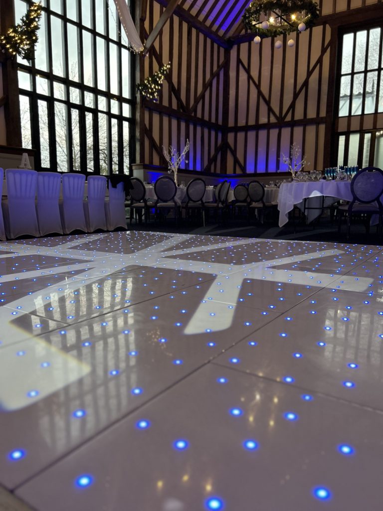 At Nextwave Events & Hire, we specialise in providing exceptional dance floor solutions to elevate your event’s atmosphere, creating an unforgettable experience for all your guests. Whether you’re planning a wedding, corporate event, or any festive occasion, our exquisite range of LED and plain dance floors are perfect for bringing a touch of elegance and vibrancy to your celebration. LED Dance Floor Hire Our LED dance floors are the pinnacle of modern event entertainment. They are designed to captivate and energise your guests, ensuring a lively and memorable party atmosphere. These stunning dance floors come with integrated LED lights that can be programmed to match the theme and color scheme of your event. With their sparkling, starlit effect, they add a magical touch to your venue, making them a popular choice for weddings and gala events. Starlit Dancefloor Hire The starlit dance floor is a crowd favorite, perfect for adding a romantic and enchanting ambiance to your event. These floors are beautifully lit with hundreds of tiny LED lights, resembling a starry night sky. They create a mesmerising effect that not only enhances the beauty of your venue but also encourages your guests to dance the night away under a canopy of twinkling stars. Serving Hertfordshire, Bedfordshire, and London We proudly serve a wide area, including Hertfordshire, Bedfordshire, and London. Our service locations include: St Albans: Known for its historical significance and beautiful architecture, St. Albans provides the perfect backdrop for our elegant dance floors. Hemel Hempstead: In the bustling town of Hemel Hempstead, our dance floors bring an extra layer of excitement and sophistication to any event. Luton: Luton’s vibrant community and diverse event venues are ideal settings for our stunning dance floors. Watford: In Watford, our dance floors complement both intimate gatherings and large-scale events, adding a touch of class and fun. Harpenden, Welwyn Garden City, and Hatfield: These picturesque towns are ideal for weddings and corporate events where our dance floors can shine. Milton Keynes: In the dynamic city of Milton Keynes, our dance floors are a popular choice for a variety of events, from corporate functions to celebratory parties. Variety of Sizes and Styles We understand that every venue and event theme is unique. That’s why we offer our dance floors in a variety of sizes and styles to suit your specific needs. Whether you’re hosting a grand ballroom gala or an intimate garden wedding, we have the perfect dance floor to fit your space and enhance your event’s overall aesthetic. Hassle-Free Installation and Removal Our team at Nextwave Events & Hire is dedicated to making your event planning process smoother and more enjoyable. We provide hassle-free installation and removal services for all our dance floors. Our professional and friendly staff ensure that the dance floor is set up safely and efficiently, ready for your guests to enjoy. After the event, we take care of the removal process, ensuring that everything is done seamlessly and with minimal disruption to you and your venue. Perfect for All Occasions Whether it’s a wedding, a corporate event, a birthday party, or any other celebration, our dance floors are designed to cater to a wide range of occasions, adding a touch of elegance and excitement to your event. The versatility of our floors means they can seamlessly integrate with various themes and settings, ensuring that they complement the tone and style of your event perfectly. Customisation to Match Your Theme We understand the importance of having every detail of your event tailored to your vision. That’s why we offer customisable options for our dance floors. From the pattern of the lights to the color schemes, we can adjust our floors to align with your event’s theme, ensuring a cohesive and stunning visual experience. Safe and Reliable Safety is paramount in our services. Our dance floors are constructed with high-quality materials and adhere to strict safety standards. They are sturdy, slip-resistant, and designed to withstand the excitement of a busy event. You can have peace of mind knowing your guests can dance safely and comfortably. Enhancing Your Event’s Atmosphere A dance floor is more than just a place for dancing; it’s a central feature that can set the tone for your entire event. Our LED and plain dance floors are designed not only for functionality but also to create an inviting and dynamic atmosphere. They encourage guests to interact, dance, and enjoy the event to its fullest, making your celebration a truly memorable one. Professional Consultation and Support At Nextwave Events & Hire, we offer professional consultation to help you choose the best dance floor for your event. Our experienced team will discuss your needs, preferences, and the specifics of your venue to recommend the most suitable options. We are committed to providing exceptional customer service and support throughout the entire process, from initial inquiry to post-event follow-up. Competitive Pricing and Packages We offer competitive pricing and packages tailored to meet a range of budgets and requirements. Whether you’re planning a lavish affair or a modest gathering, we have options that will provide excellent value without compromising on quality or style. Building Lasting Memories Our ultimate goal is to help you create lasting memories. A dance floor is where many special moments happen, from the first dance at a wedding to the joyous celebration at a milestone birthday party. With Nextwave Events & Hire, you can trust that these moments will be cherished and remembered for years to come. Contact Us for Your Next Event Ready to add a spectacular dance floor to your next event in Hertfordshire, Bedfordshire, or London? Contact Nextwave Events & Hire today. Let us help you make your event not just an occasion but an experience that stands out and remains etched in the hearts and minds of all your guests.